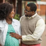 Smiling African American pregnant couple